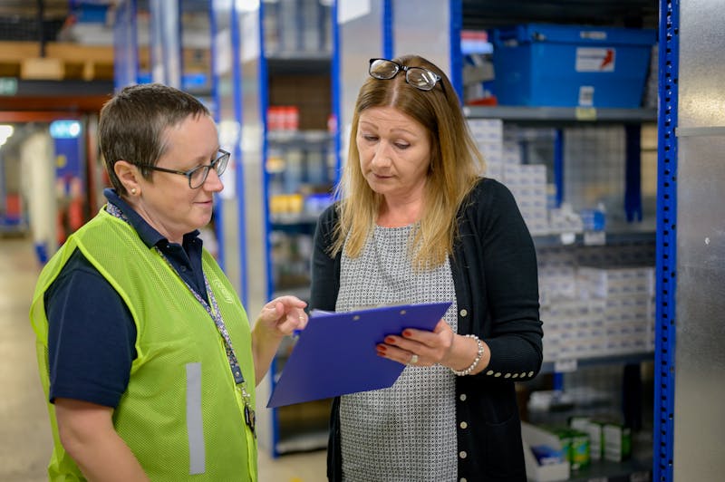 Team reviewing delivery schedule in warehouse