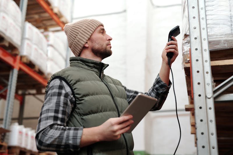Worker scanning products for specification verification